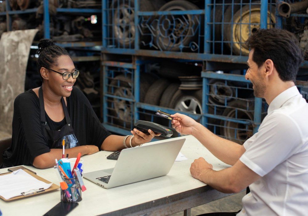 Female African American car auto parts owner Accepting credit card payments from customers in auto parts stores. business warehouse motor vehicle.