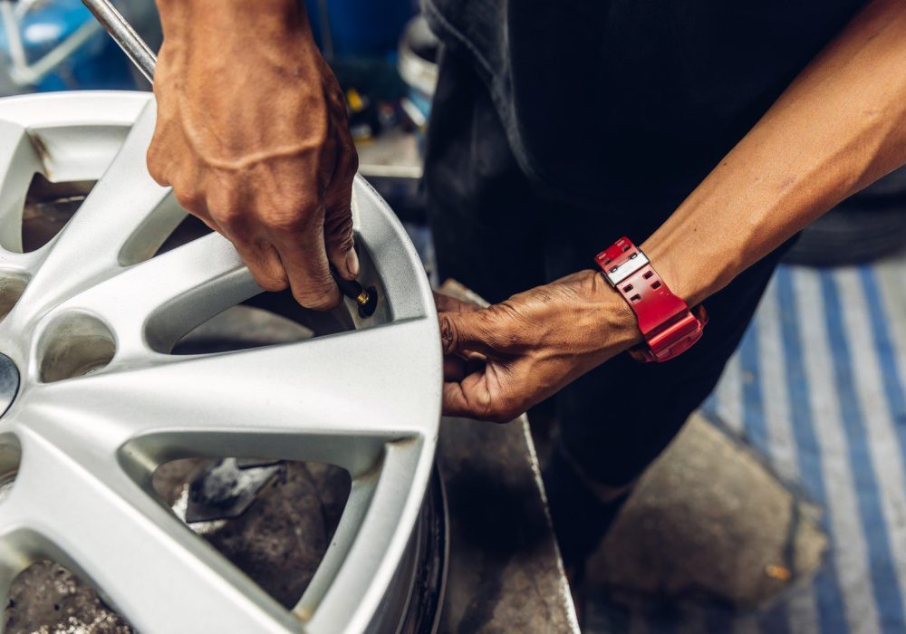 Mechanic removing a tire from the rim after using a tire bead breaker at  shop. workers remove the tire from the rim with a tire-removing machine device,Mechanic repairing tire.